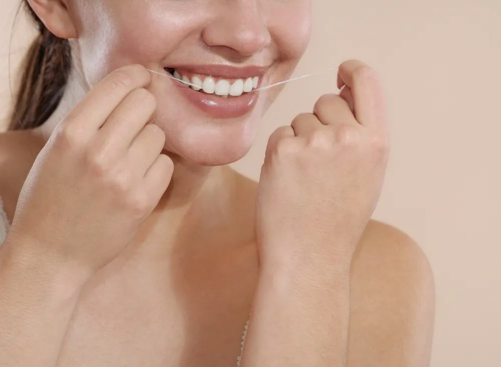 women flossing her teeth