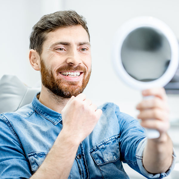 man holding a mirror and smiling